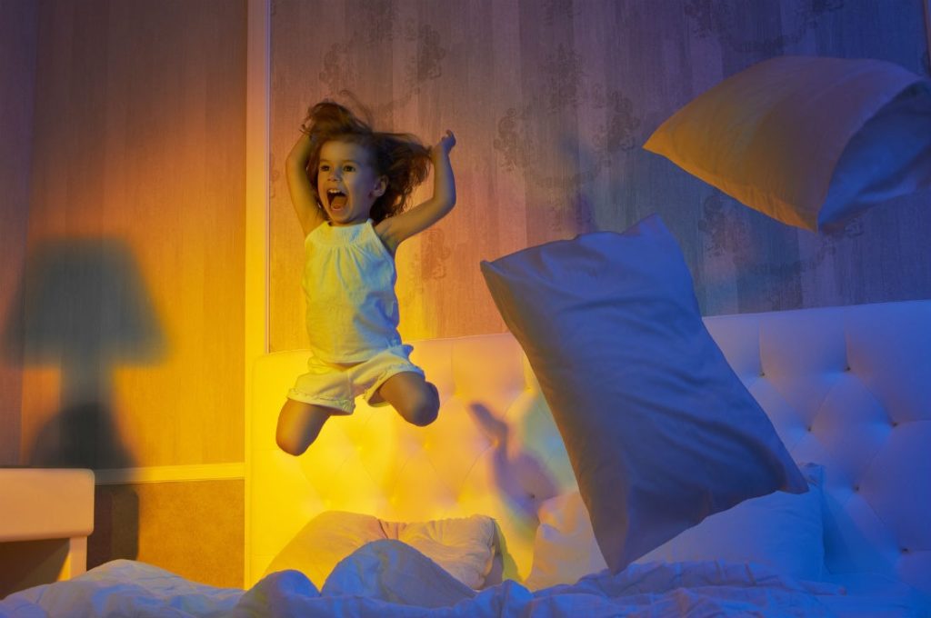Девочка прыгает по кровати